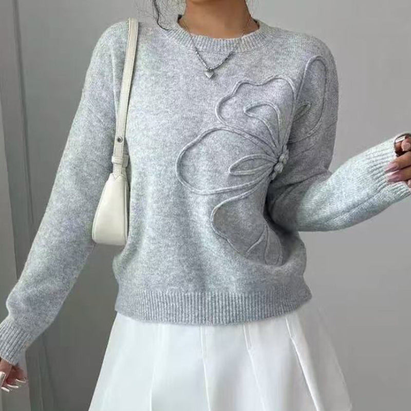 Woman wearing a stylish elegant floral knit sweater, a comfortable long sleeve crew neck pullover for autumn.
