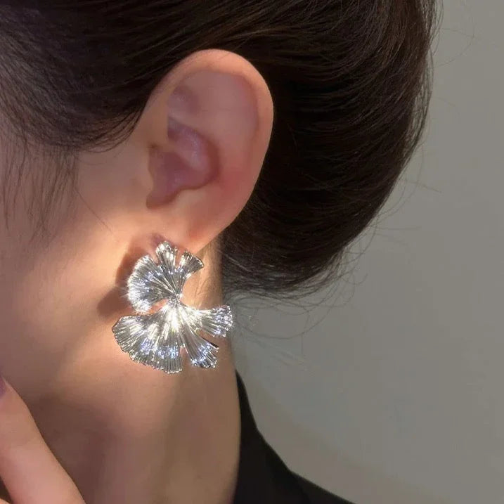 Delicate gold and silver flower dangle earrings for women. Elegant floral jewelry with a sophisticated touch.