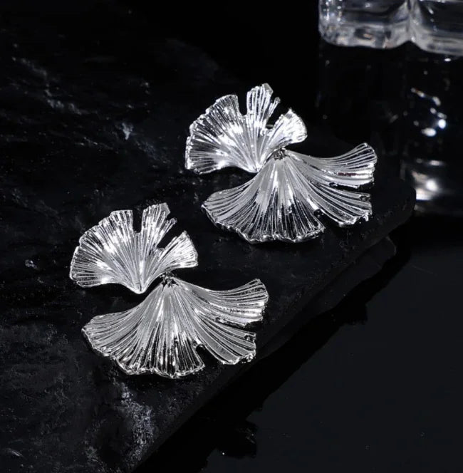Two-tone gold and silver flower dangle earrings. Elegant women's jewelry, perfect for a sophisticated look.