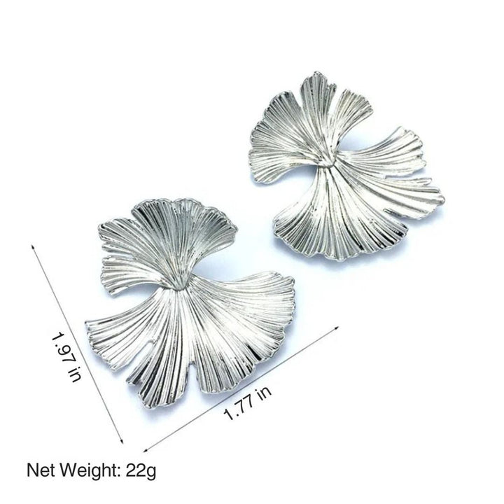 Close-up of elegant women's flower dangle earrings, featuring gold and silver petals. Sophisticated jewelry.