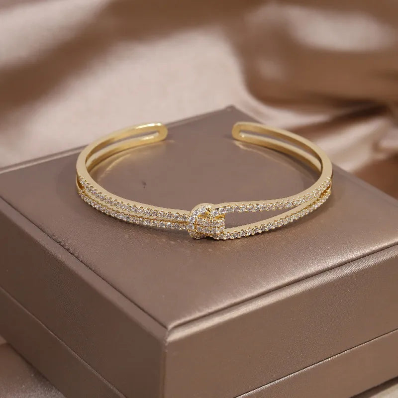 Women's elegant gold knot crystal bangle bracelet, a sparkling fashion accessory.