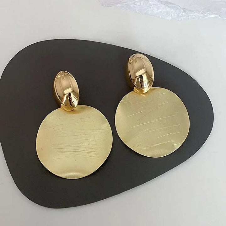 Women's elegant gold-plated round pendant earrings. Modern fashion jewelry, perfect gift for her.