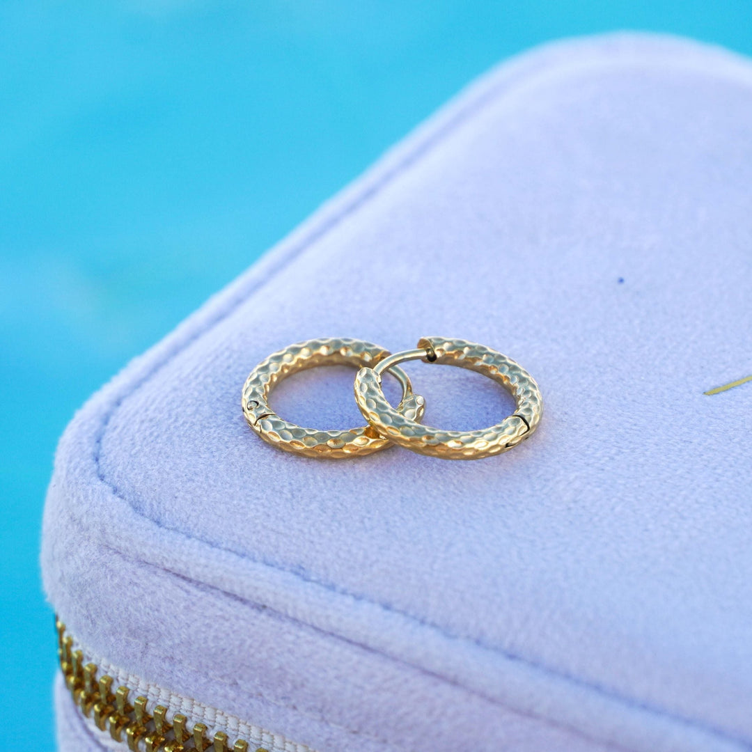 Woman wearing elegant hammered gold hoop earrings, highlighting daily wear fashion appeal.