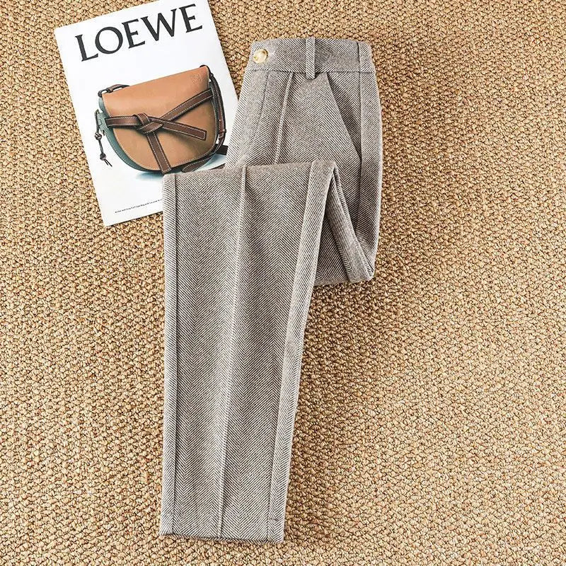 Close-up of elegant women's herringbone trousers fabric, showcasing the sophisticated pattern.