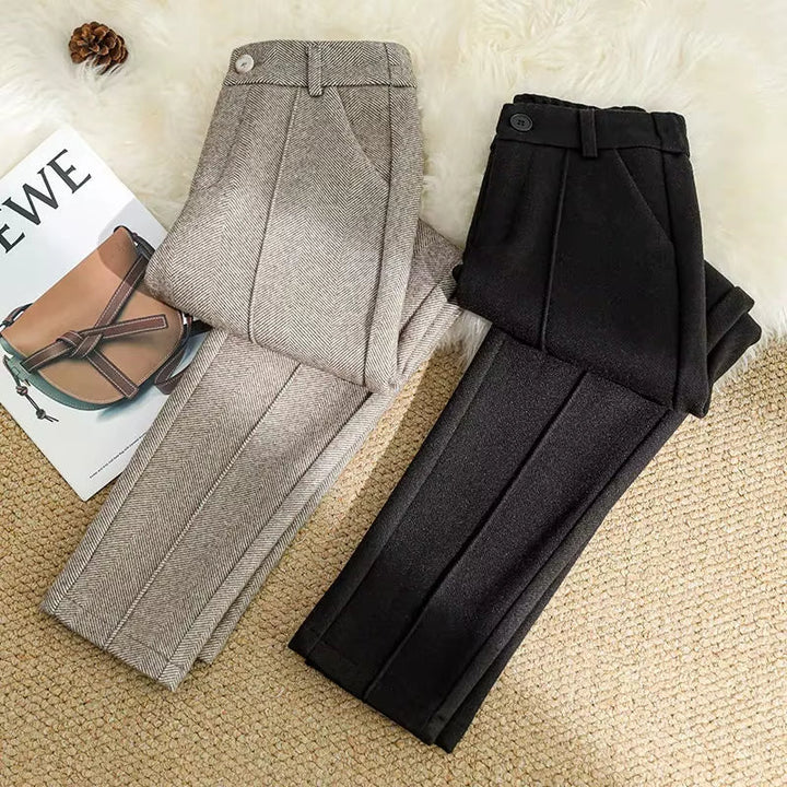 Detailed view of high-waisted women's herringbone trousers, showing the tailored waistband and clean finish.