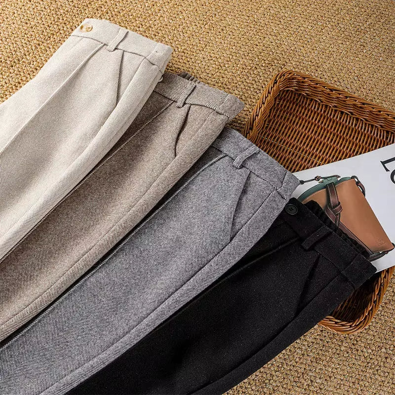 Women's elegant herringbone trousers styled with a blouse, showcasing a chic, professional work outfit.