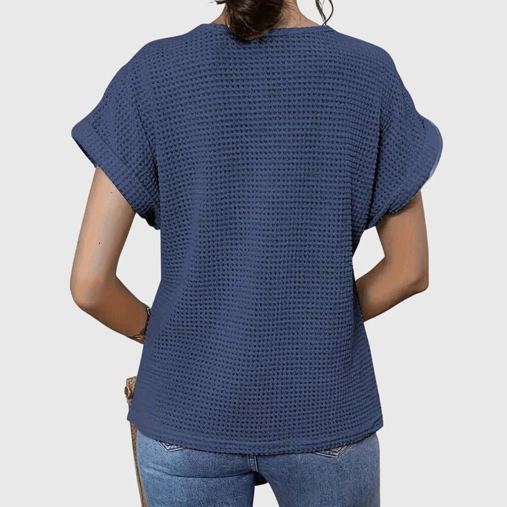 Versatile women's elegant blouse with lace, ideal for resort wear. Side view emphasizes its flattering fit.