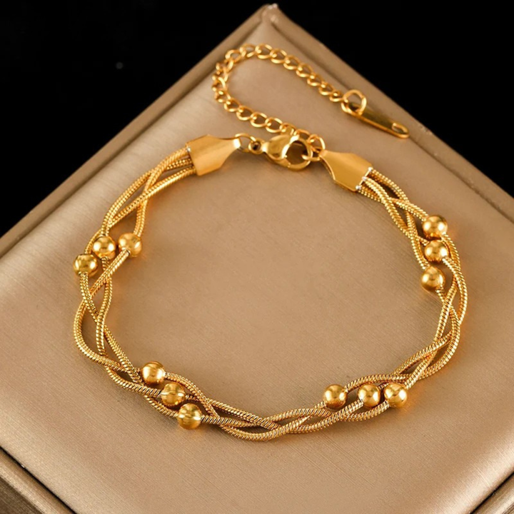 Women's elegant layered snake chain bracelet in gold-tone stainless steel, adjustable. Chic women's jewelry.