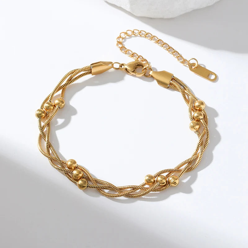 Minimalist women's gold layered snake chain bracelet, made of adjustable stainless steel. Sophisticated chic jewelry.