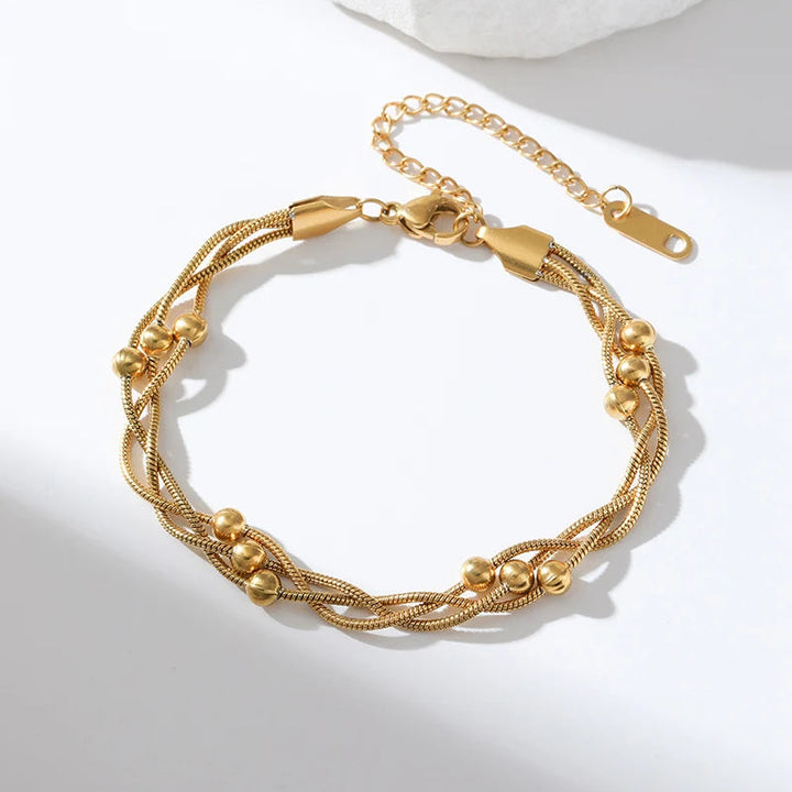 Minimalist women's gold layered snake chain bracelet, made of adjustable stainless steel. Sophisticated chic jewelry.