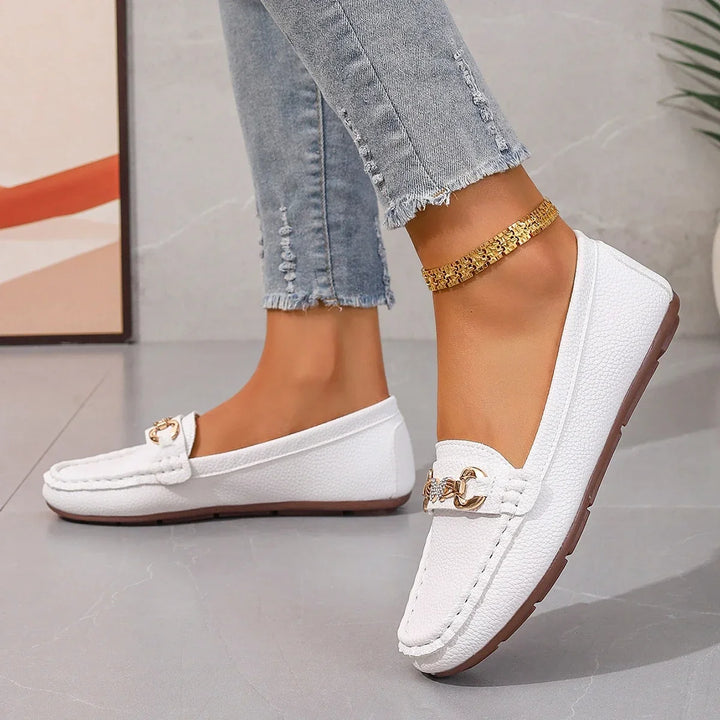 Close-up of a women's loafer showcasing the sparkling crystal chain detail and material texture.