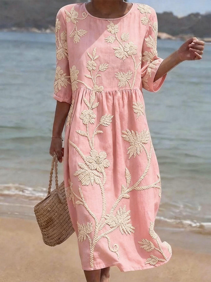 Close-up of embroidered floral details on a women's casual midi dress with three-quarter sleeves. Spring fashion.