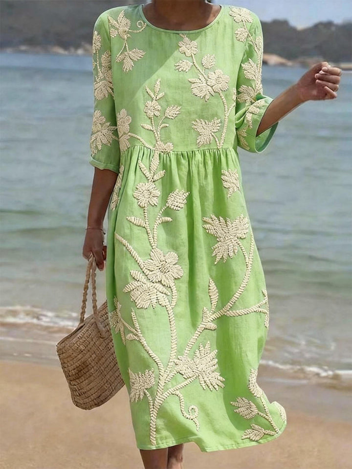 Stylish women's embroidered midi dress featuring three-quarter sleeves, ideal for summer or spring day fashion.