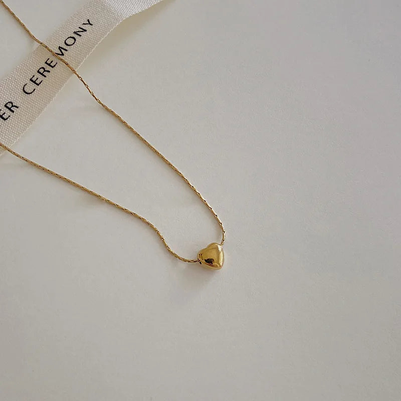 Dainty minimalist heart necklace for women, sleek gold-tone stainless steel. Elegant & versatile jewelry.
