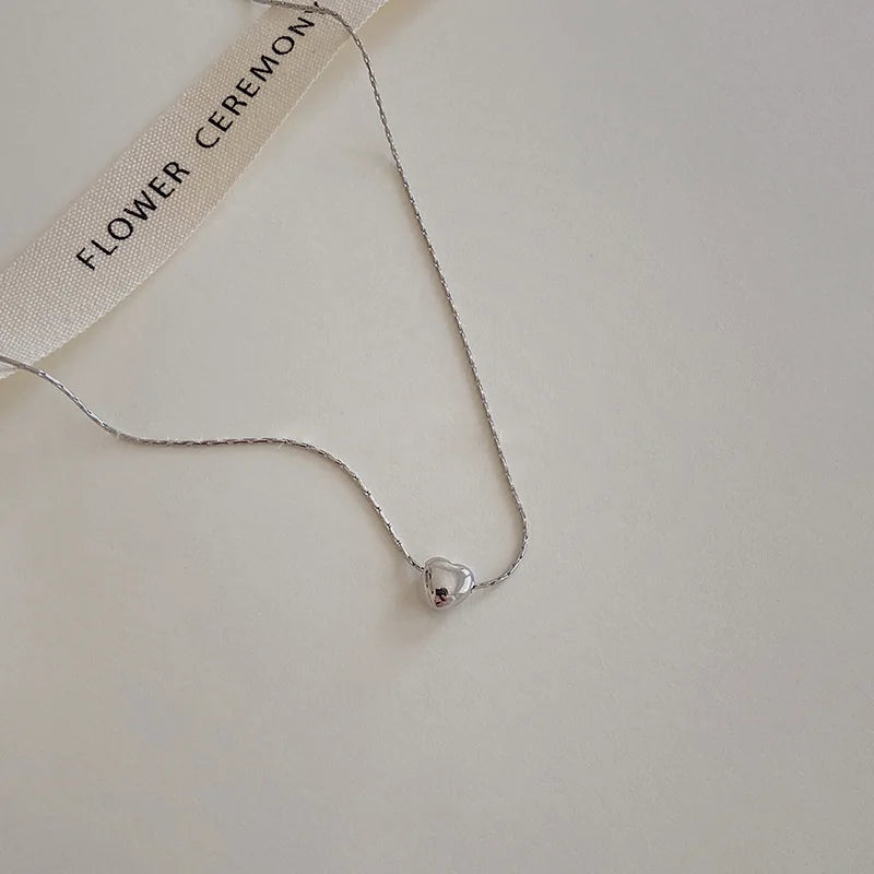 Versatile minimalist heart necklace, elegant dainty design. Perfect women's jewelry in sleek silver.