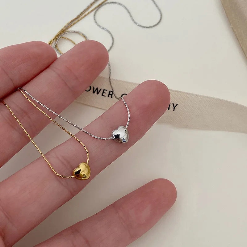 Close-up of a sleek minimalist heart necklace for women, elegant stainless steel, perfect dainty accessory.