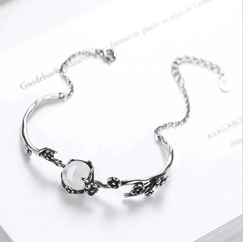 Close-up of a women's sterling silver bracelet featuring a captivating oval moonstone, adjustable and elegant.