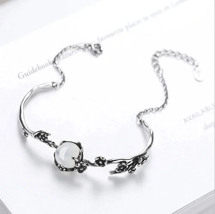 Close-up of a women's sterling silver bracelet featuring a captivating oval moonstone, adjustable and elegant.