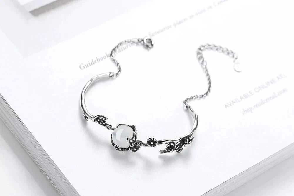 Adjustable women's silver bracelet showcasing a beautiful, iridescent moonstone. Elegant and versatile jewelry.