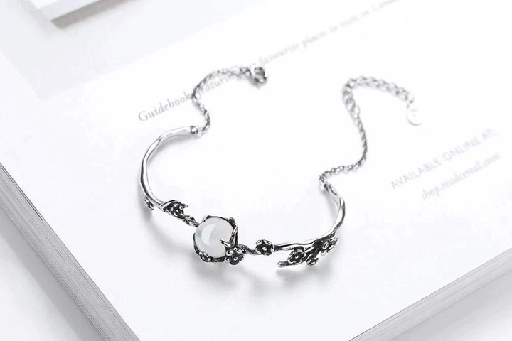 Adjustable women's silver bracelet showcasing a beautiful, iridescent moonstone. Elegant and versatile jewelry.