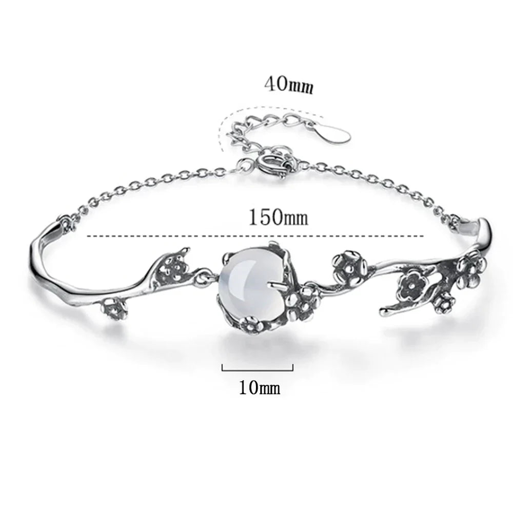 Sparkling women's silver bracelet with a central moonstone, reflecting light beautifully. A chic gemstone accessory.