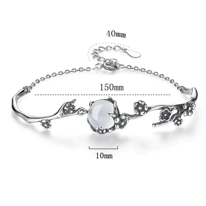 Sparkling women's silver bracelet with a central moonstone, reflecting light beautifully. A chic gemstone accessory.