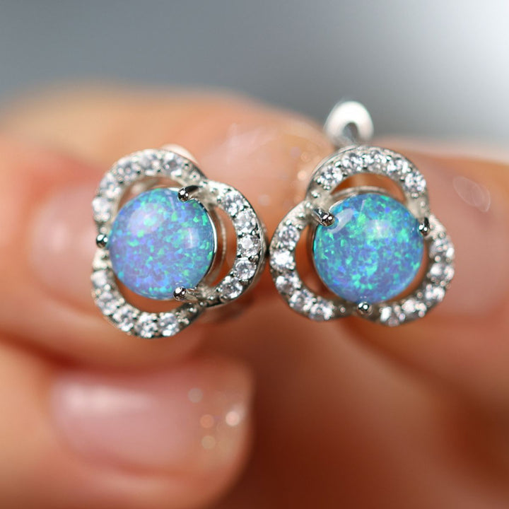 Close-up of women's lucky clover leaf stud earrings, radiant opal & zircon.
