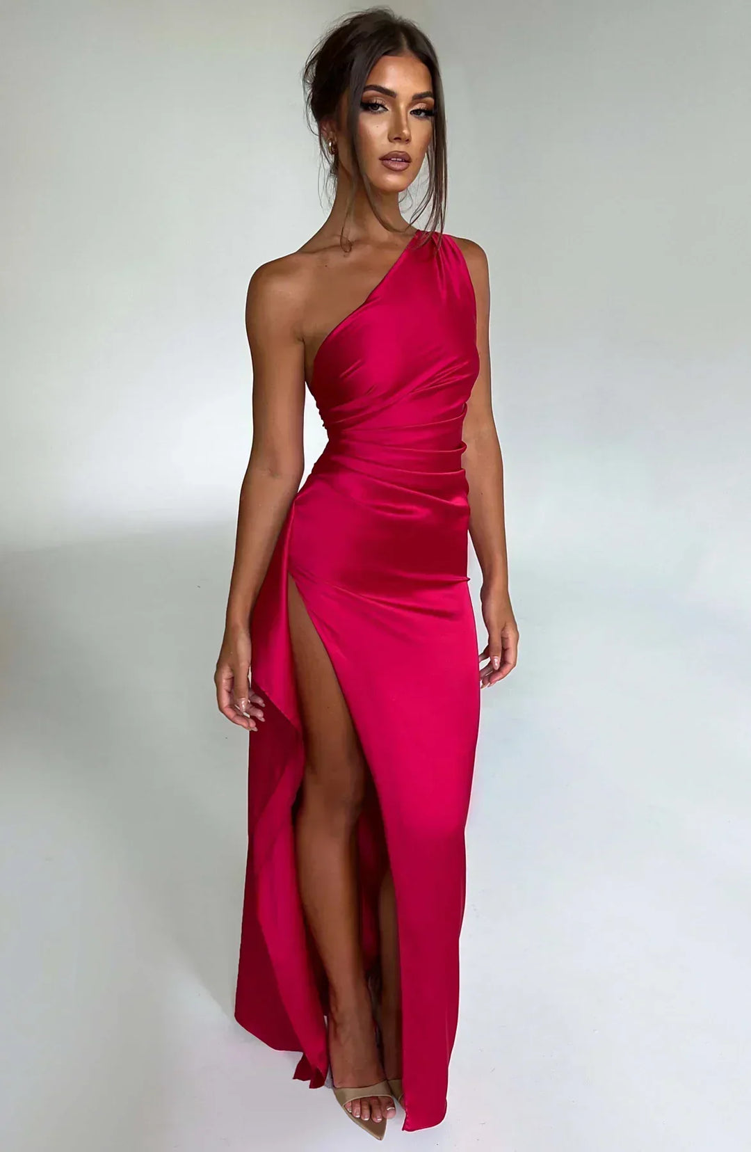 Women's elegant red pleated satin dress with unique shoulder detail, perfect for formal events.