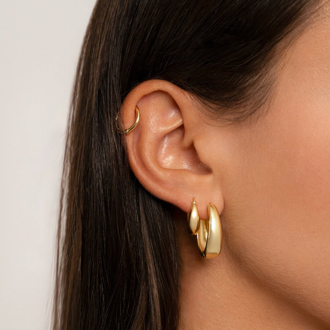 Close-up of S925 sterling silver hoop earrings with luxurious 18K gold plating, highlighting craftsmanship.