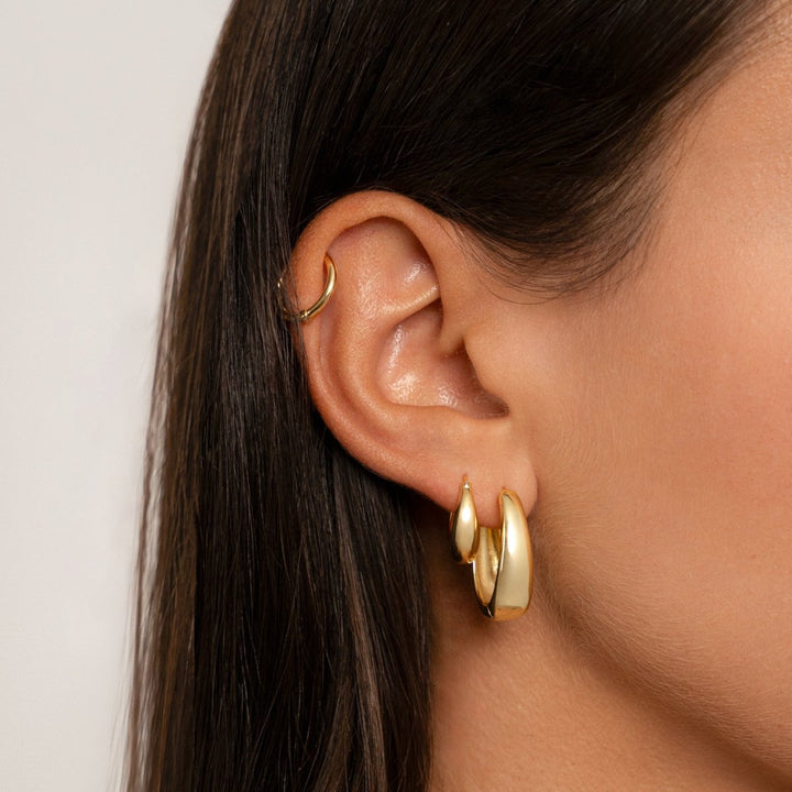 Close-up of S925 sterling silver hoop earrings with luxurious 18K gold plating, highlighting craftsmanship.