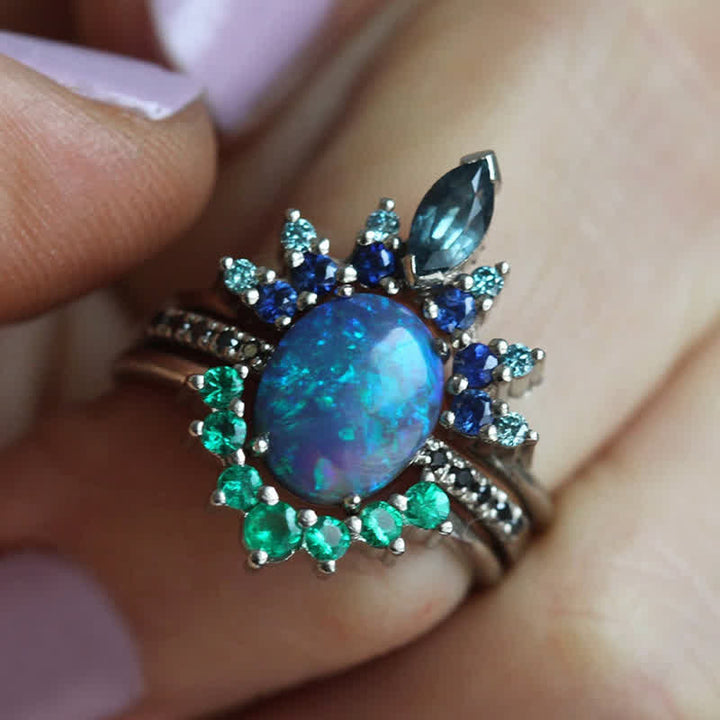 Close-up of women's sapphire & opal 3-piece ring set. Elegant gemstone, fine jewelry, stackable rings.