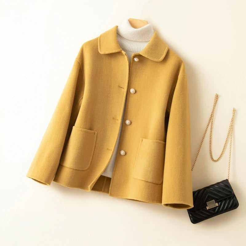 Women's elegant short coat with doll collar, front pockets, & button closure. Perfect for sophisticated autumn layering.