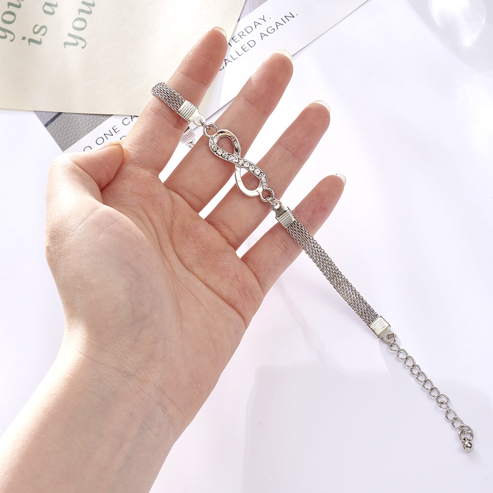 Close-up of a woman's wrist adorned with an elegant sterling silver infinity bracelet.