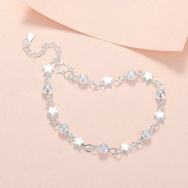 Adjustable sterling silver bracelet with delicate star charms, an elegant women's jewelry accessory.