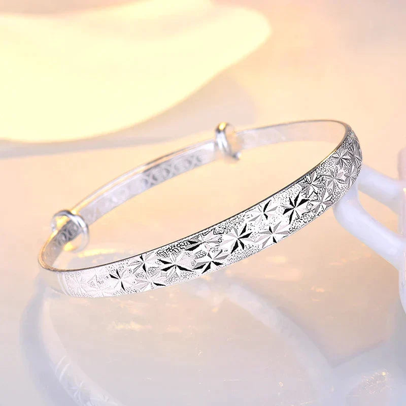 Dainty sterling silver star charm bracelet, adjustable for women, adds a touch of elegance.