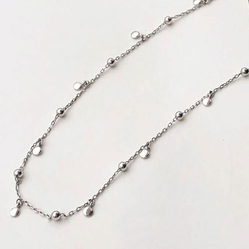 Detailed view of a women's elegant silver teardrop necklace, sterling silver fashion jewelry.