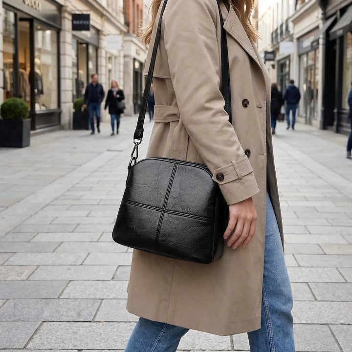 Women's elegant stitched panel crossbody shoulder bag in black, perfect for fashion accessories.