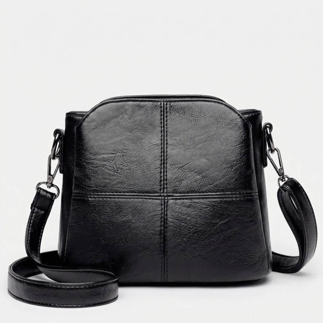 Fashionable women's stitched panel crossbody bag; a sleek, essential accessory for any outfit.