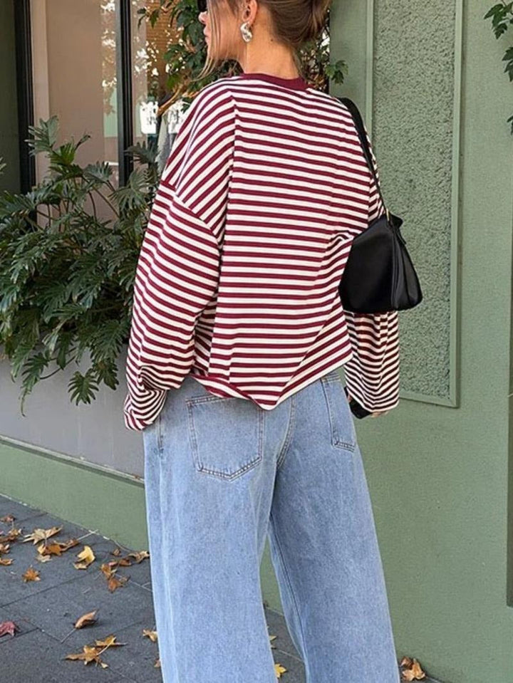 Modern women's striped bell sleeve blouse. This elegant, sophisticated top offers a relaxed fit and stylish design.