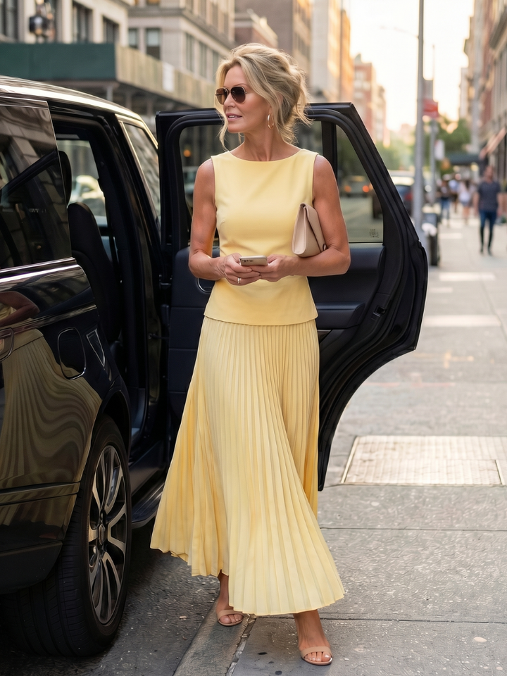 Women's chic long skirt set with a sleeveless structured top and a beautifully draped pleated maxi skirt.