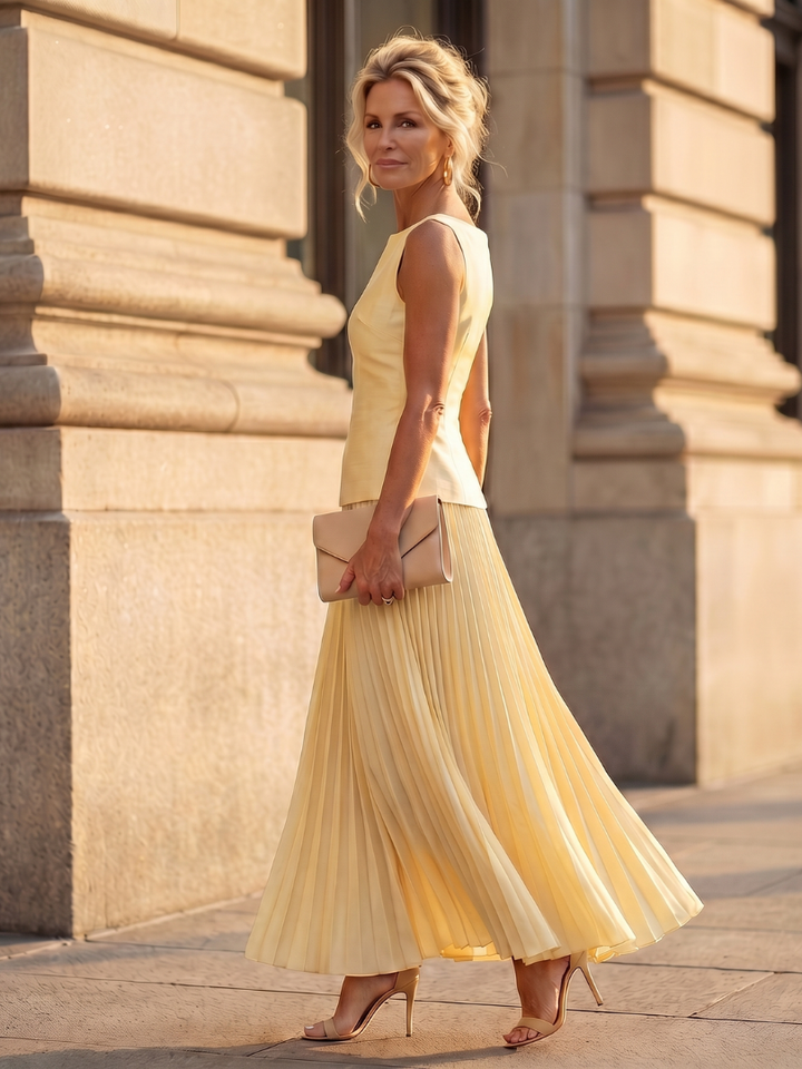 Chic two-piece women's outfit: sleeveless top with structured bodice & flowy pleated maxi skirt.