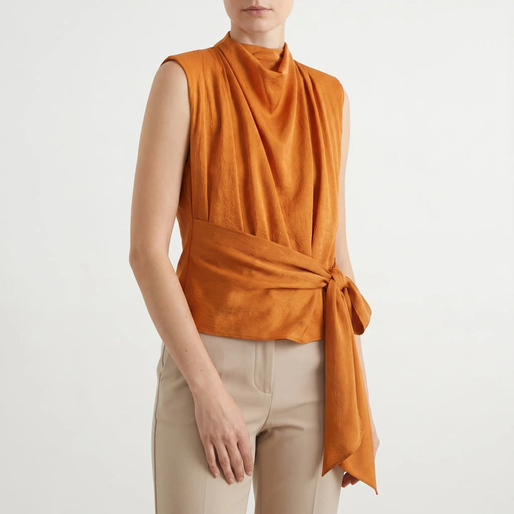 Sophisticated women's sleeveless blouse with draped neckline & adjustable tie-waist for evening wear.