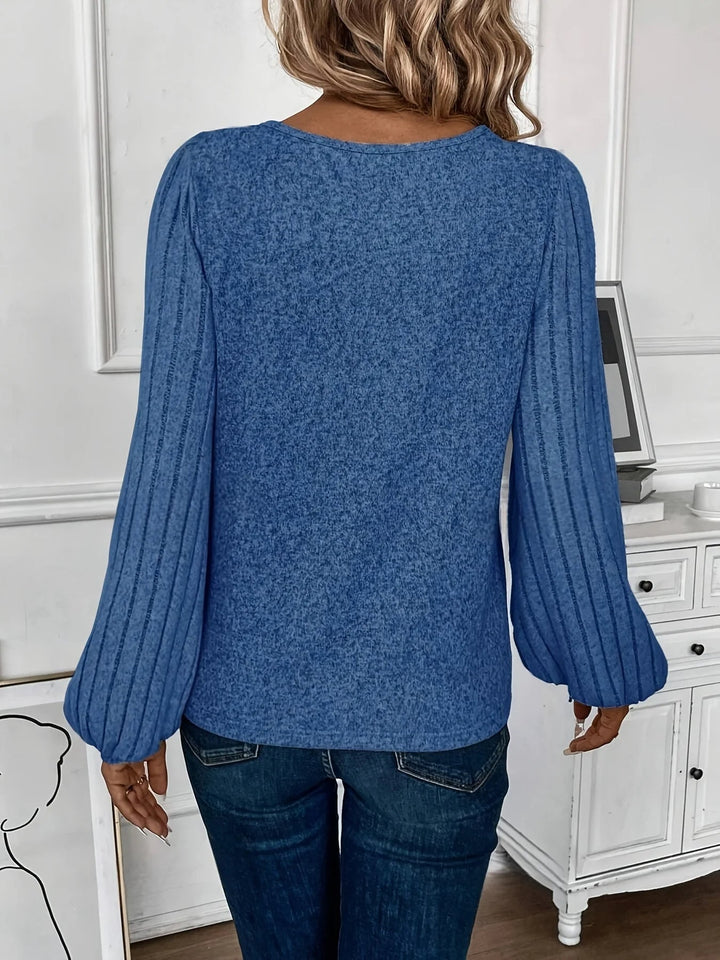 Cozy women's V-neck knit sweater featuring elegant balloon sleeves and a comfortable, relaxed fit.