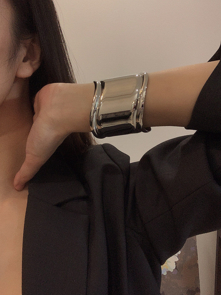 Close-up of a delicate sterling silver wave bracelet, women's elegant fashion jewelry.