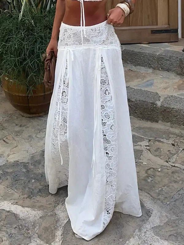 Close-up of a women's elegant white maxi skirt, highlighting delicate lace panel details & flowy fabric.