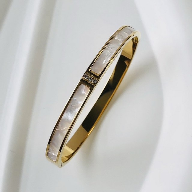 Close-up of a women's dazzling zircon inlay bangle, elegant jewelry accessory.