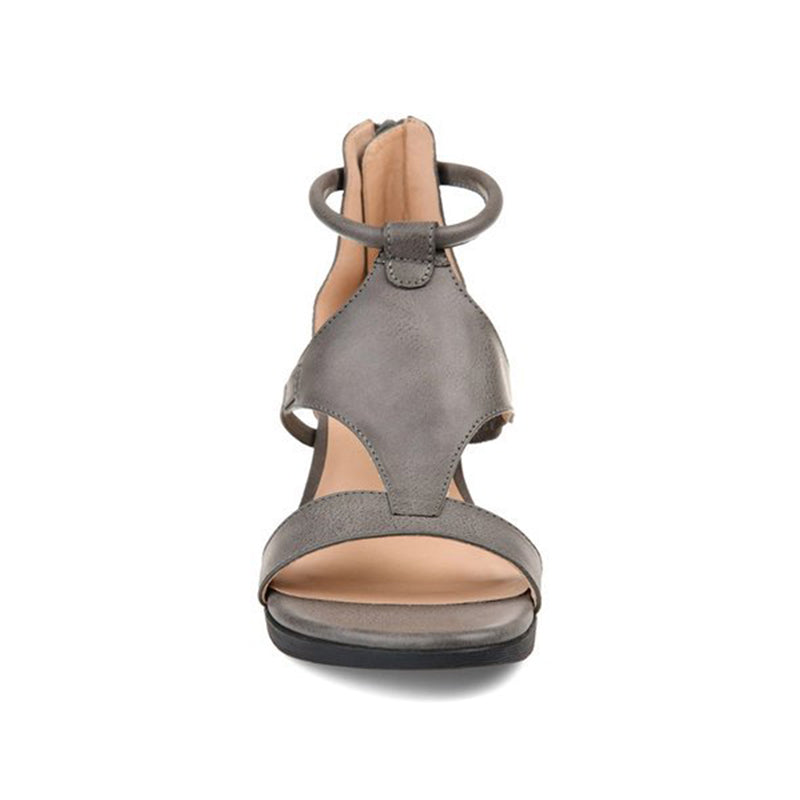 Woman wearing comfortable elevated heel sandals with an adjustable ankle strap, perfect for casual or dressy.