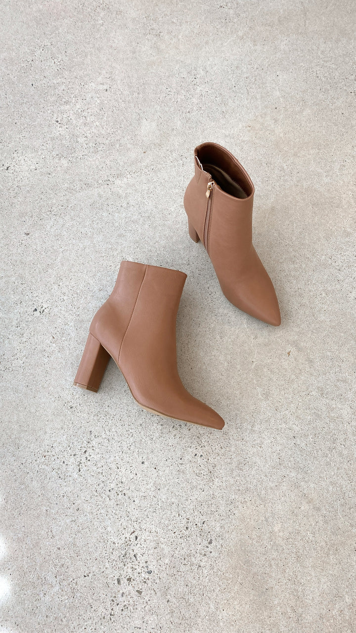Close-up of women's casual ankle boots, showcasing the block heel and pointed toe details.