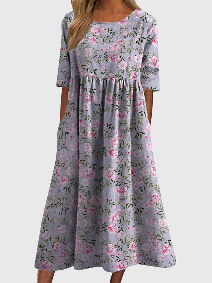 Rear view of a flattering women's flowy midi dress, showcasing its elegant drape and embroidered details.