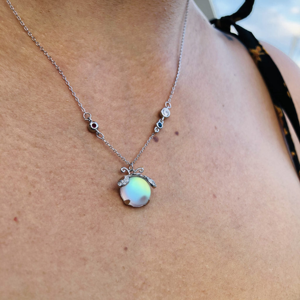 Magical women's moonstone necklace with a delicate firefly pendant, elegant silver jewelry.